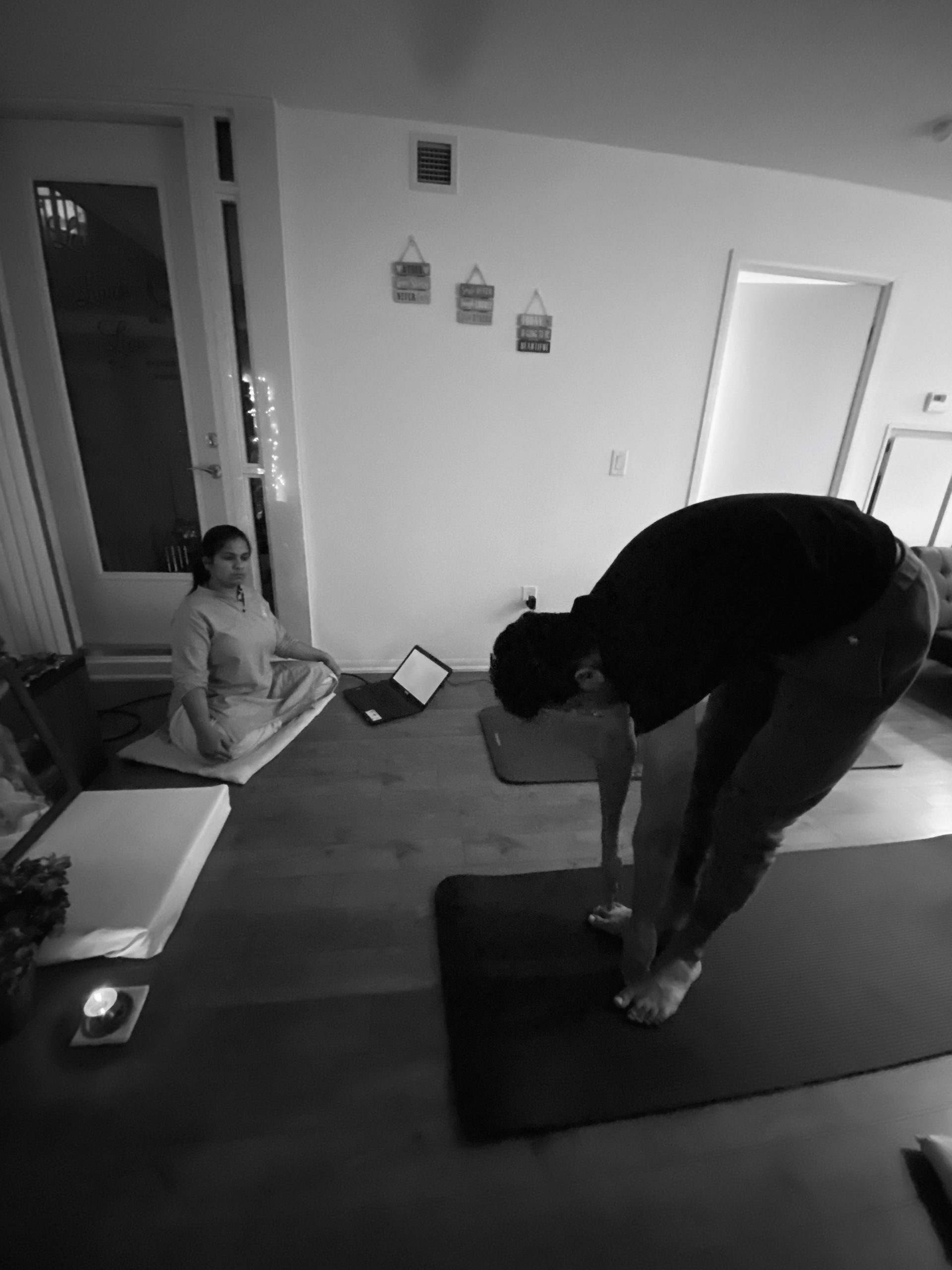 A teacher teaching in a small, cozy yoga studio.