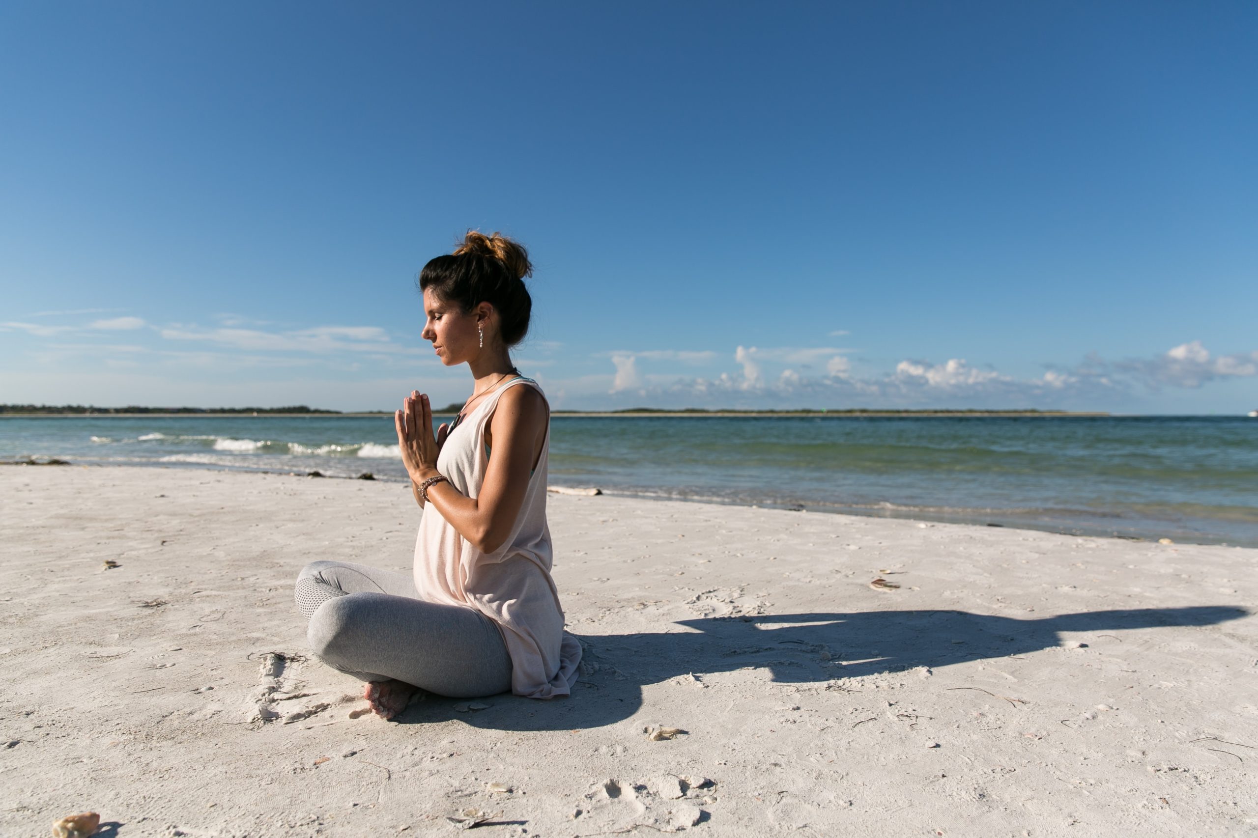 A pregnant lady doing yoga on beach