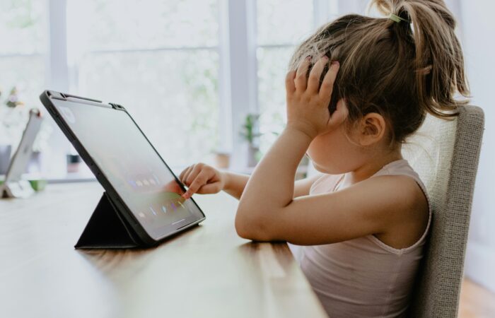 A little girl glued to the screen