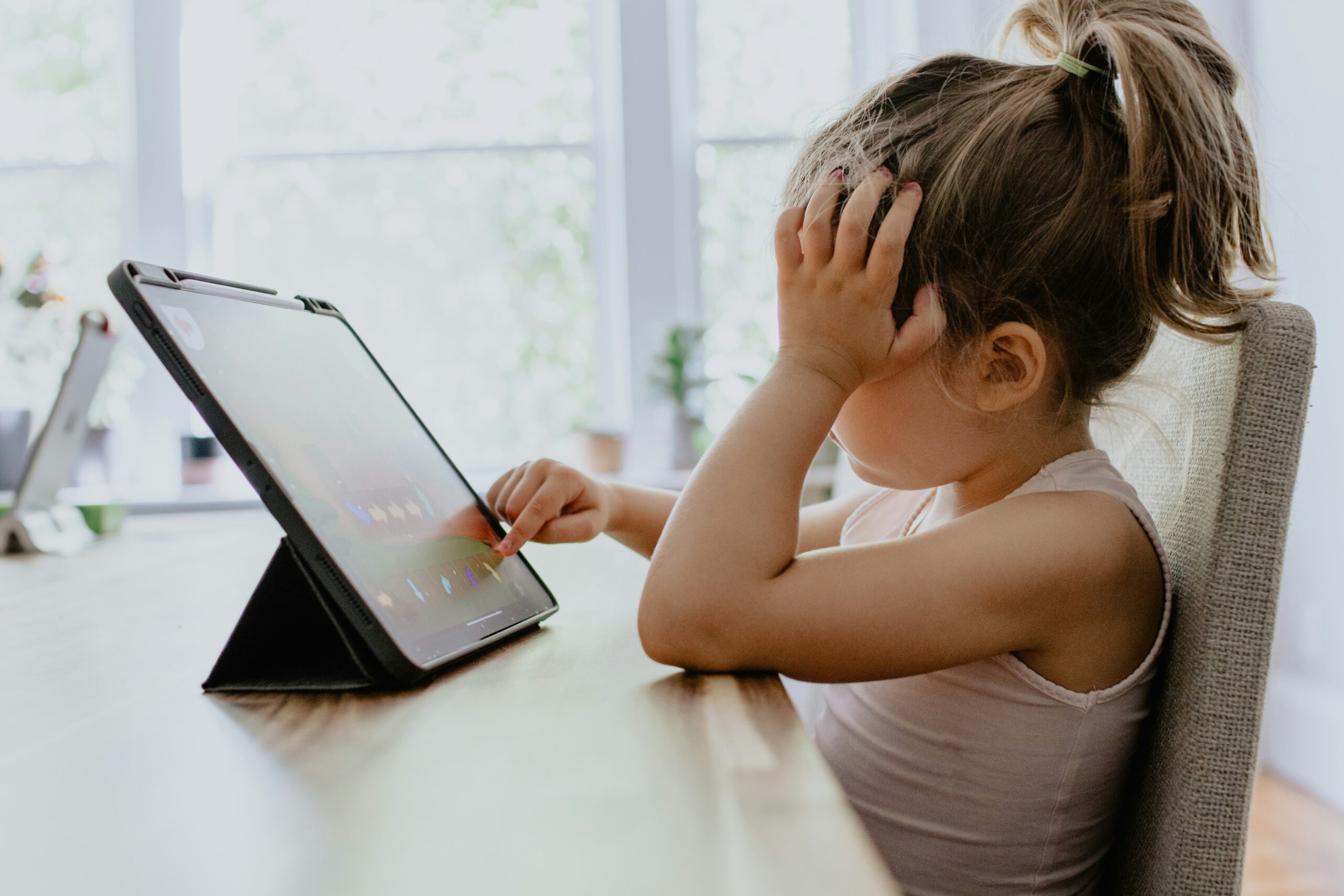 A little girl glued to the screen